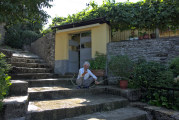 Gjirokastra - Pflanzen bewässernder alter Mann vor Hauseingang auf langer Treppe
